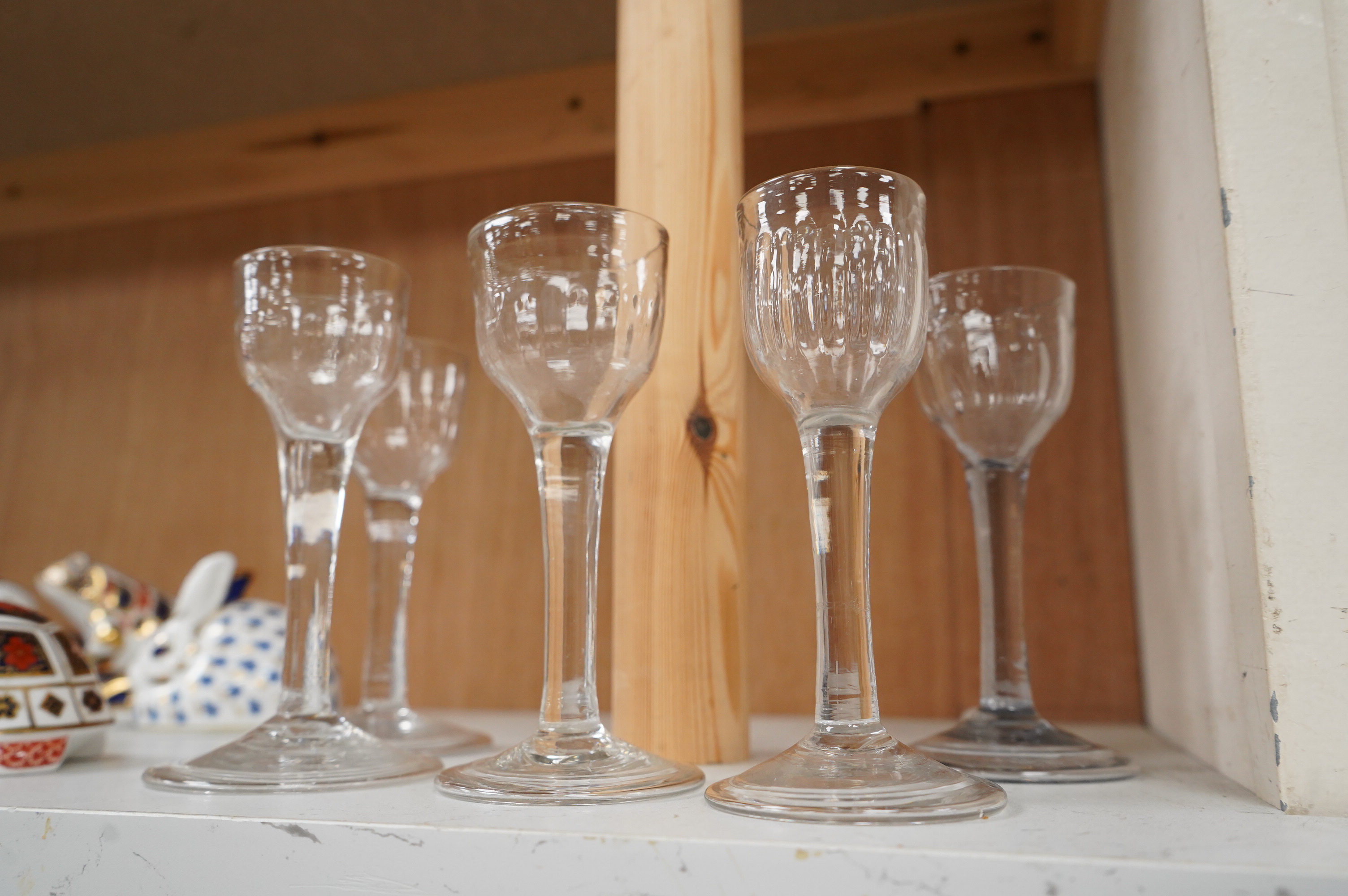 Five 18th century cordial glasses, in lead and soda glass, with fluted bowls, columnar stems, on domed and folded feet, 13.5cm high